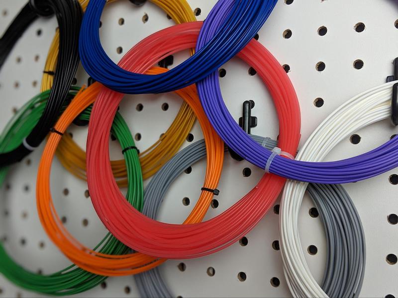 Несколько мотков нитей (филаментов) из PLA пластика разных цветов